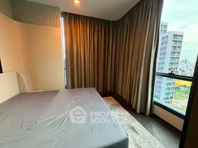 Modern bedroom with large windows offering stunning city views in a high-rise apartment.