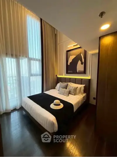 Luxurious bedroom with floor-to-ceiling windows and elegant decor in modern apartment.