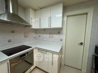 Modern kitchen with sleek white cabinets and built-in oven