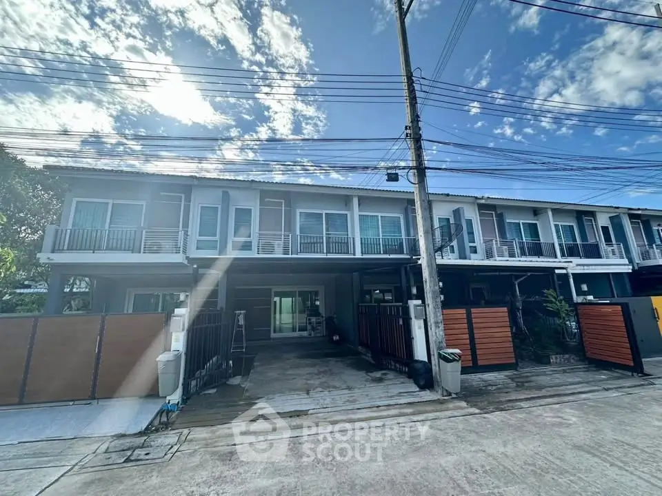 Modern townhouse exterior with clear blue sky and spacious driveway