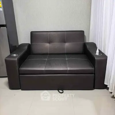 Modern leather sofa with built-in cup holders in a stylish living room setting.