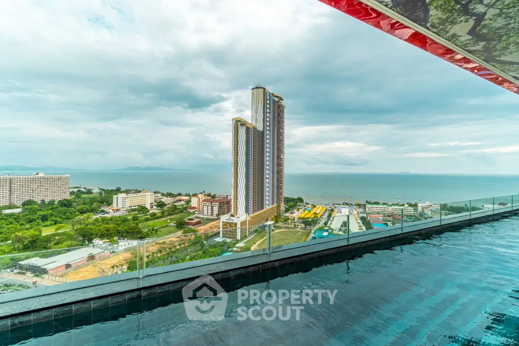Luxurious rooftop pool with stunning ocean view and modern high-rise building.