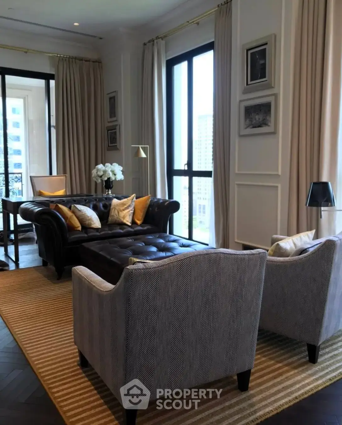 Luxurious living room with elegant furniture and large windows offering city views.