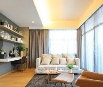 Modern living room with cozy seating and natural light, featuring stylish decor and a workspace.