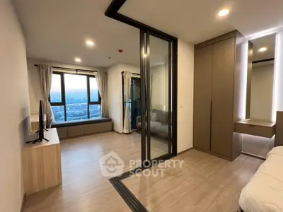 Modern apartment interior with city view, featuring sleek design and ample natural light.