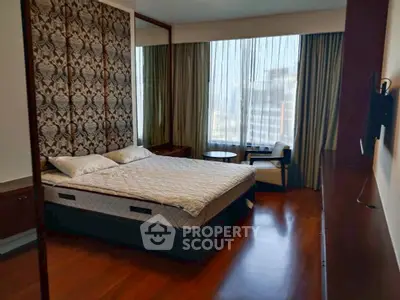 Luxurious bedroom with elegant decor and large window offering city views.