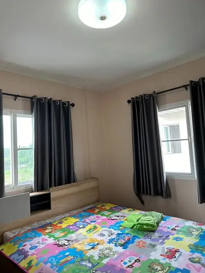 Cozy bedroom with colorful bedding and ample natural light from two windows.