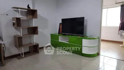 Modern living room with sleek green TV stand and open shelving unit, bright and inviting space.