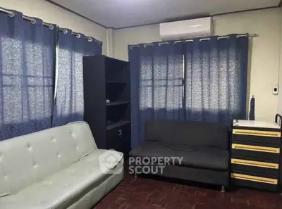 Cozy living room with modern furniture and air conditioning, perfect for relaxation.