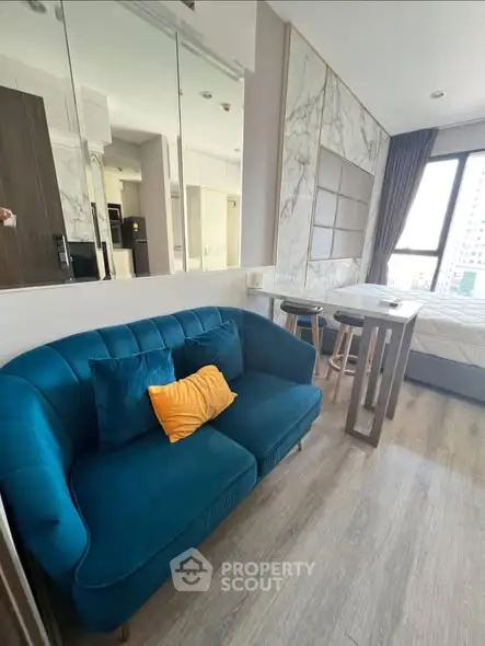 Modern studio apartment with stylish blue sofa and elegant decor