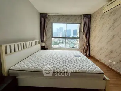 Spacious bedroom with large window offering stunning city view, featuring modern decor and air conditioning.