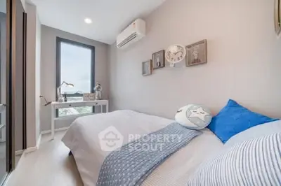 Cozy modern bedroom with stylish decor and large window offering natural light.