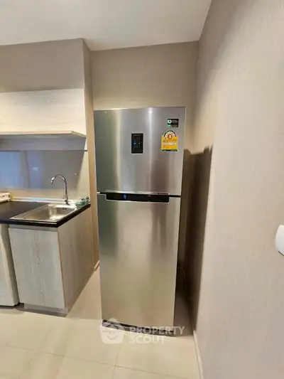 Modern kitchen with sleek stainless steel fridge and stylish cabinetry.