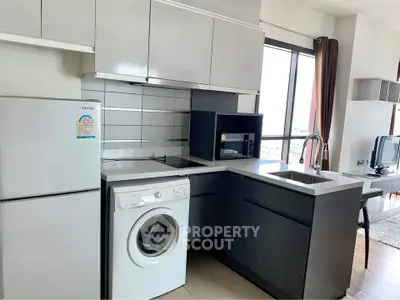 Modern kitchen with washing machine and sleek cabinetry in a bright apartment