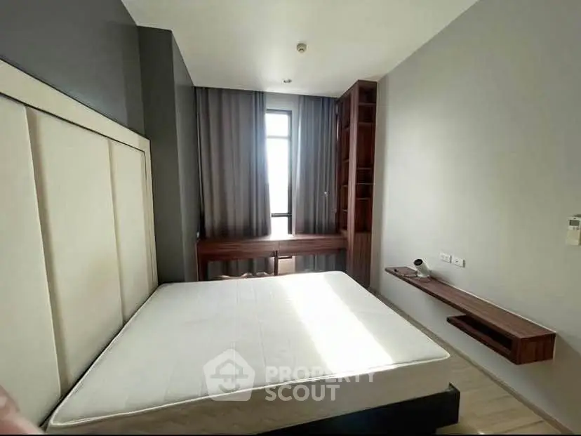 Modern bedroom with large window and built-in wooden furniture