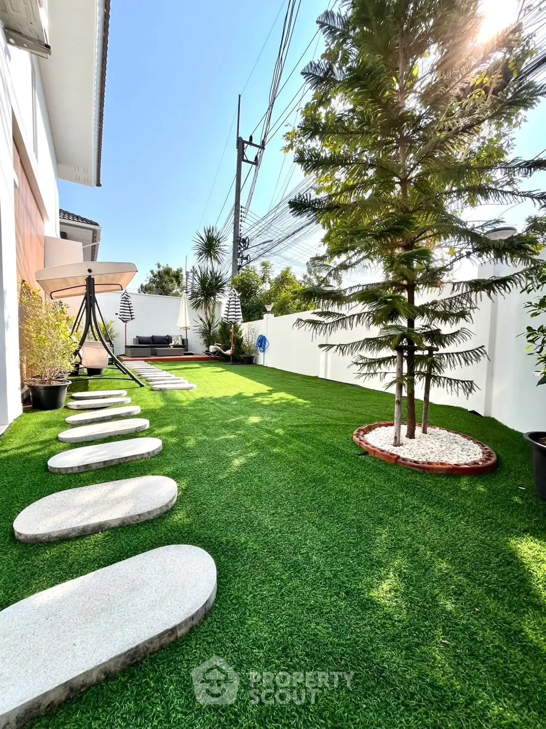 Luxurious garden with stepping stones and lush greenery in modern real estate property.
