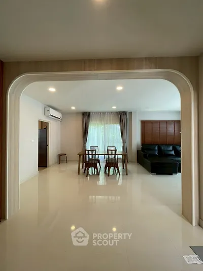 Spacious modern living room with elegant dining area and large windows.