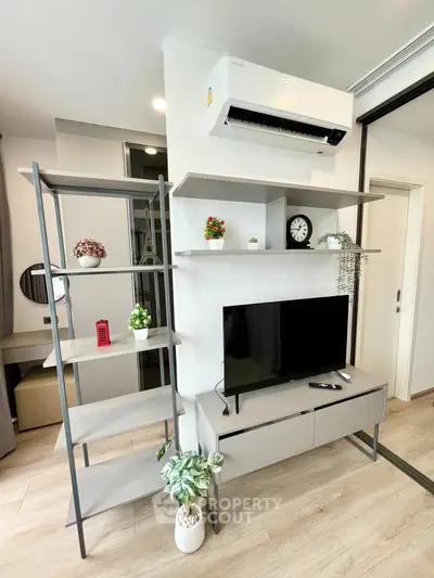Modern living room with sleek shelving, TV unit, and air conditioning, perfect for contemporary urban living.