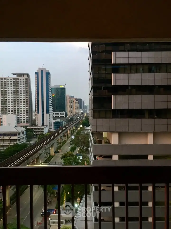 Stunning urban view from a high-rise balcony overlooking city skyline and railway.