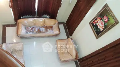 Elegant living room with leather furniture and floral artwork, perfect for cozy gatherings.