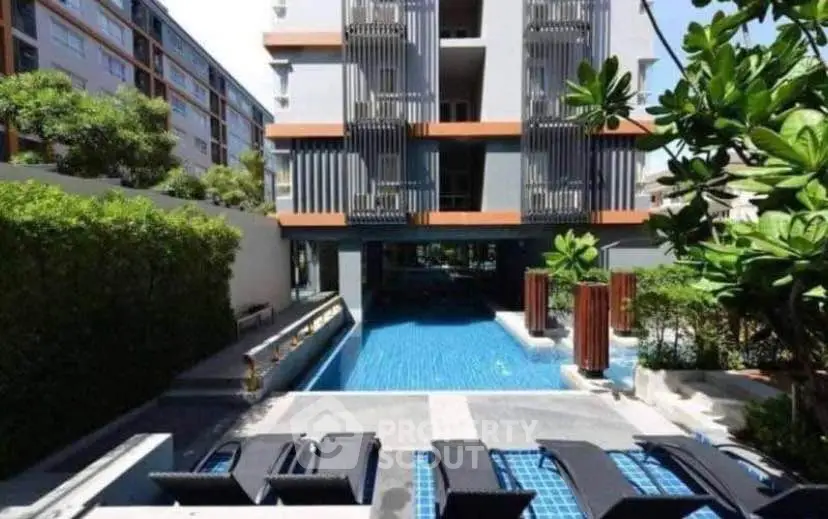 Modern apartment building with pool and lush greenery, perfect for luxury living.