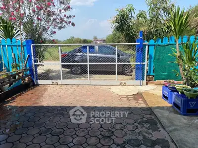 Charming garden entrance with vibrant plants and secure gate, perfect for privacy and outdoor enjoyment.