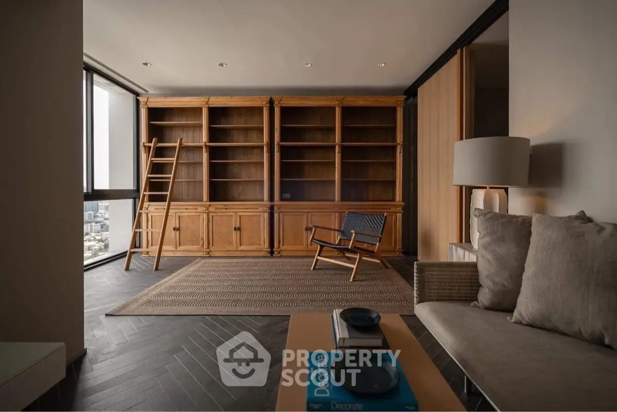 Spacious living room with wooden bookshelves and city view, featuring modern furniture and elegant decor.