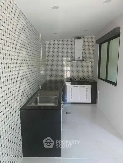 Modern kitchen with sleek black countertops and patterned backsplash