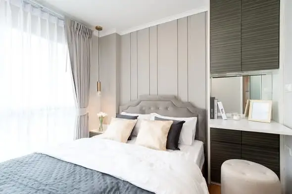 Modern bedroom with elegant decor and natural light in a stylish apartment.