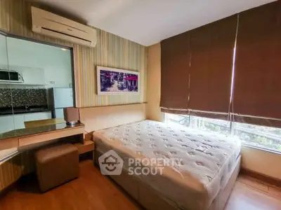 Cozy bedroom with large window and modern decor in a stylish apartment.