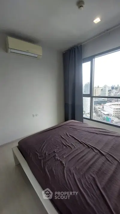 Modern bedroom with city view and air conditioning in high-rise apartment