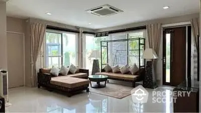 Spacious living room with modern furniture and large windows offering natural light.