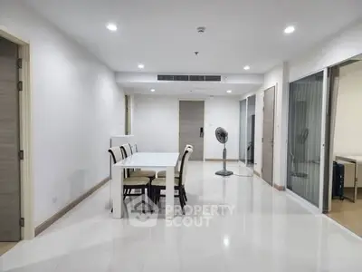 Spacious modern dining area with sleek white table and chairs, ideal for family gatherings.