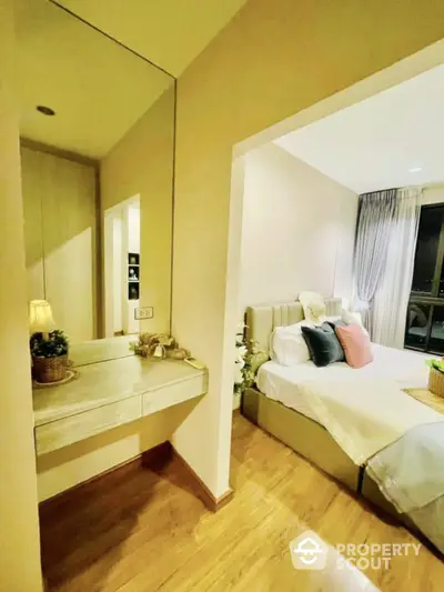 Elegant bedroom with cozy decor and natural light, featuring a stylish vanity area.