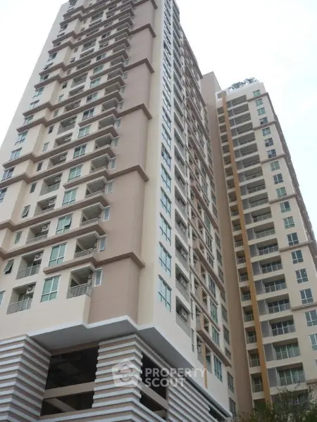 Modern high-rise residential building with multiple balconies and sleek design.