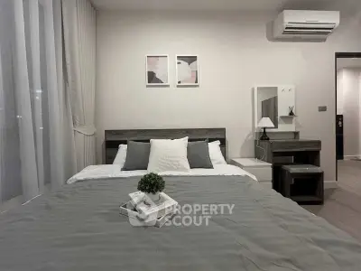 Modern bedroom with stylish decor and air conditioning, featuring a cozy bed and elegant furnishings.