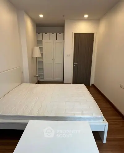 Spacious bedroom with modern design and ample storage in a stylish apartment.