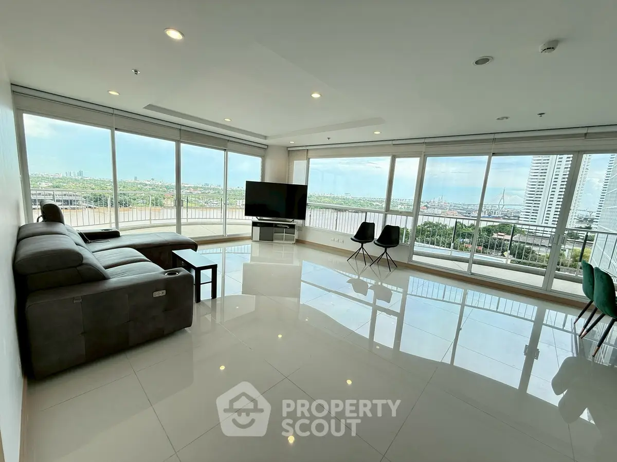 Spacious living room with panoramic city views and modern furnishings.