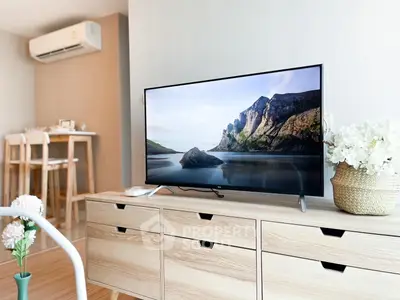 Modern living room with stylish wooden furniture and large TV, perfect for relaxation and entertainment.