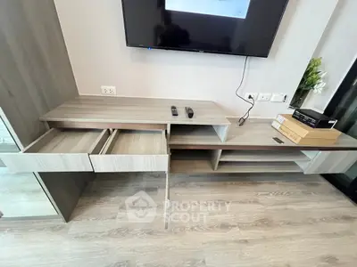Modern living room with sleek wooden TV console and open storage drawers.