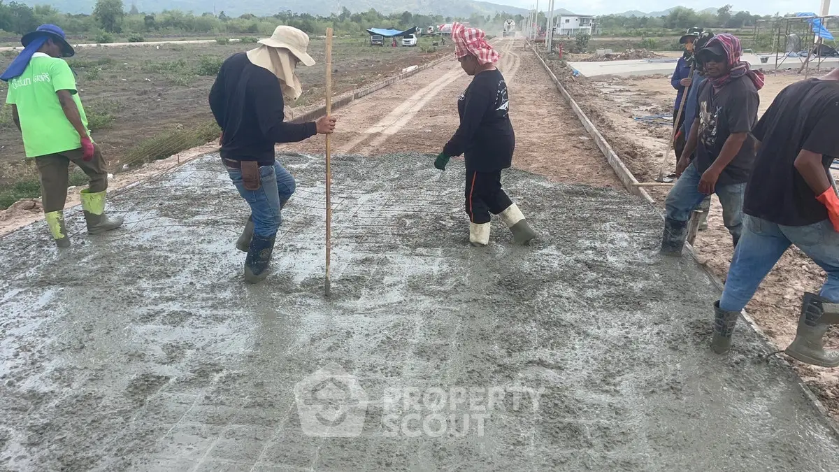 Construction workers pouring concrete for new road development
