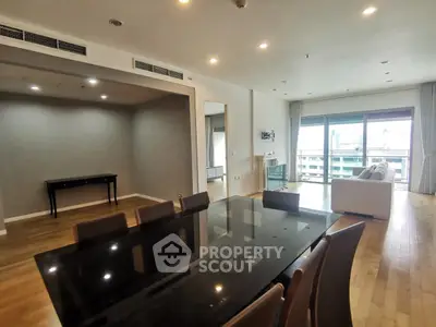 Spacious modern living room with dining area and large windows in a luxury apartment.