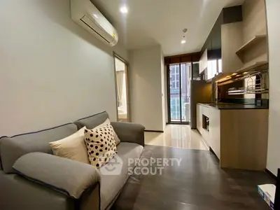 Modern apartment living room with sleek kitchen and cozy sofa, perfect for urban living.