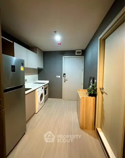 Modern kitchen with sleek appliances and stylish cabinetry in a contemporary apartment.