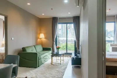 Modern living room with green sofa and city view balcony in stylish apartment