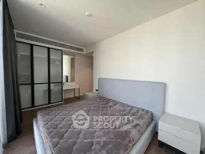 Modern bedroom with stylish bed and large wardrobe in a bright apartment.
