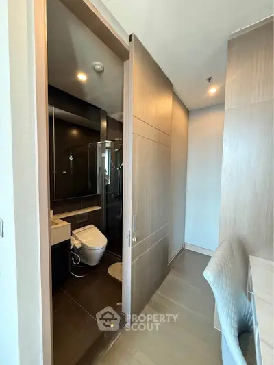 Modern bathroom with sleek design and sliding door in a contemporary apartment.