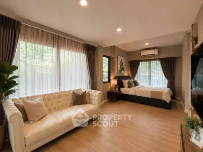 Spacious bedroom with elegant decor and large windows for natural light