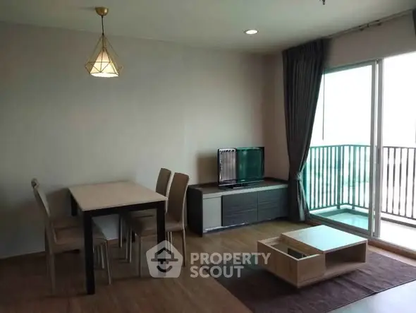 Modern living room with dining area and balcony access in a stylish apartment.