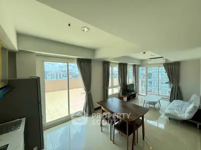 Spacious living room with large windows and balcony access in modern apartment